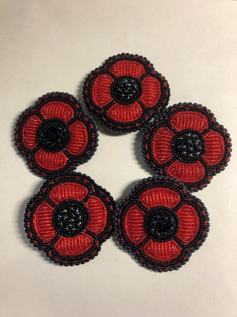 Photo of five beaded poppies by guest speaker, Naomi Smith