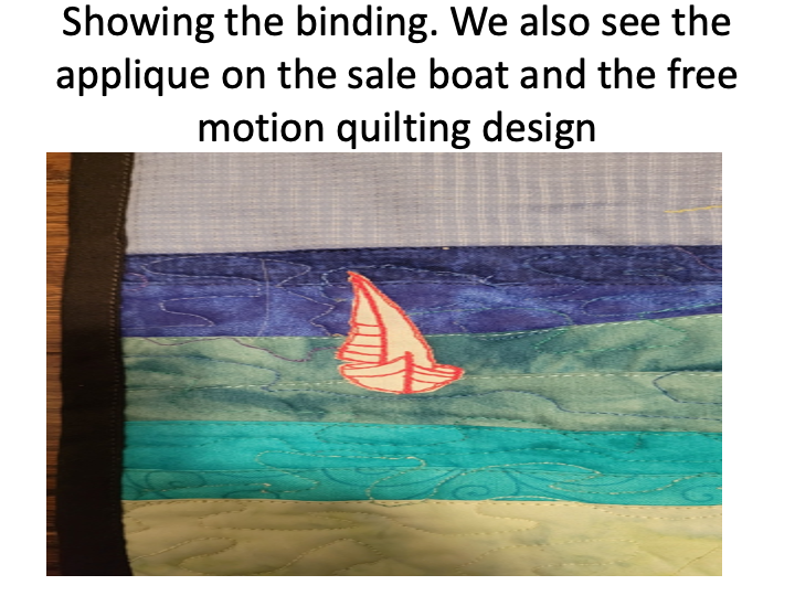 Photo showing the binding on Beach Glass Penguin along with the applique sail boat and free motion quilting design