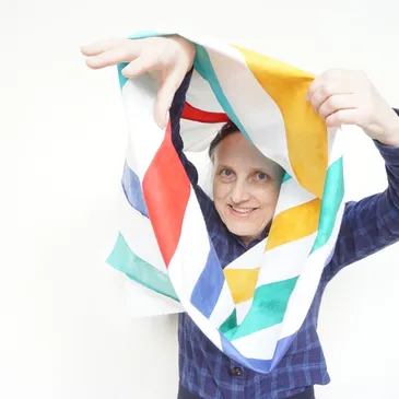 Photo of guest speaker, Irena Swanson, looking through a tube of fabric