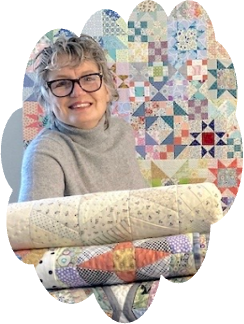 Photo of guest speaker, Sandy Lindal, holding some of her quilts