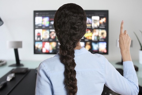 Woman watching people on television screen
